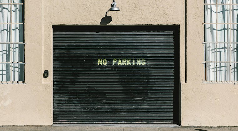 Black metal roll-up door with no parking print